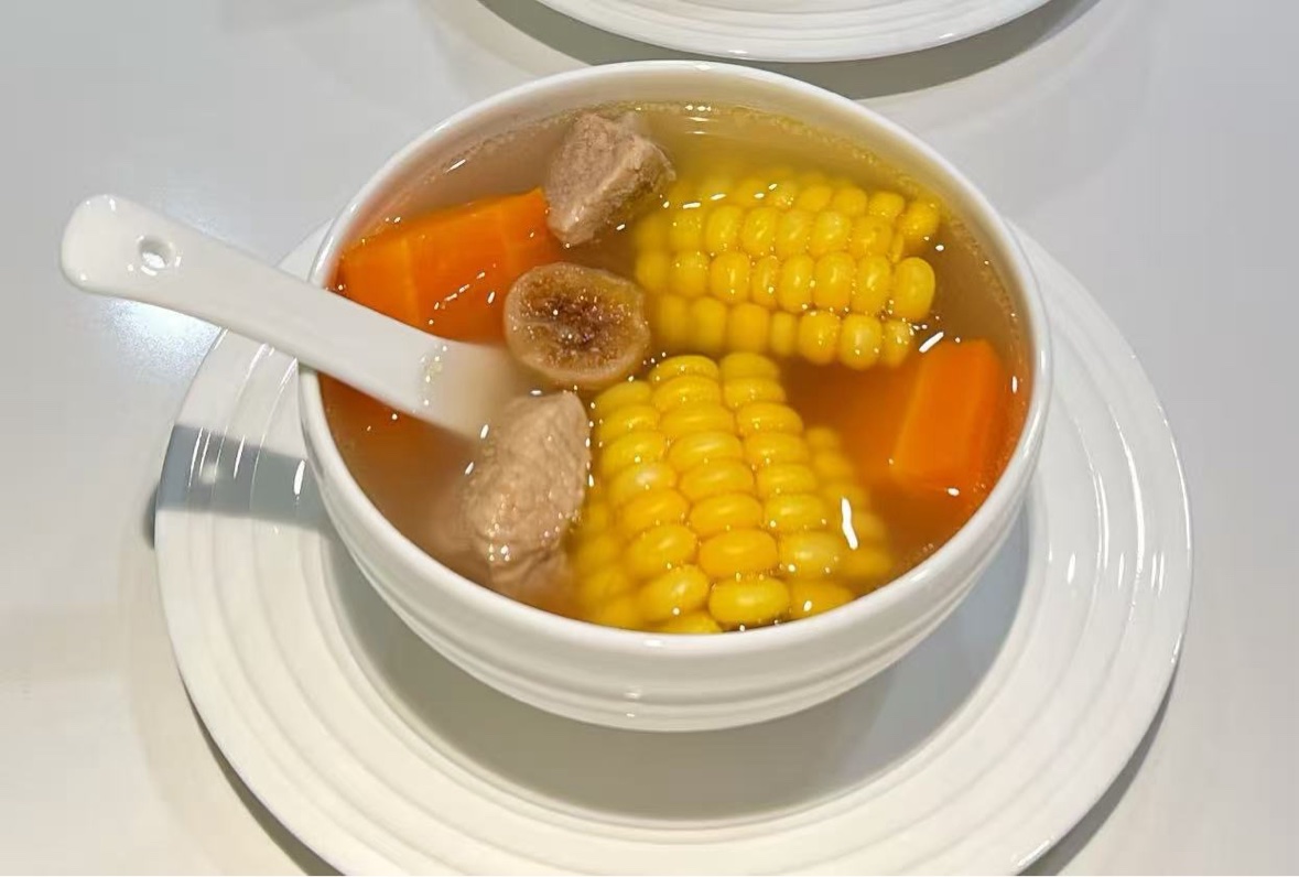 Clear corn, carrot, fig, and meat soup